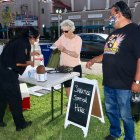Visitors to Hanford's first Thursday night Market Place follow the rules with masks and checking in at the sanitation station.